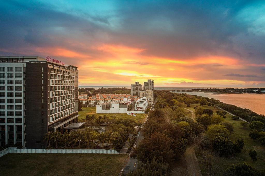 een uitzicht op een stad met een zonsondergang op de achtergrond bij Crowne Plaza Tainan, an IHG Hotel in Anping