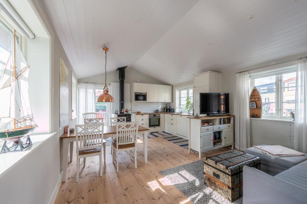 a kitchen and living room with a table and chairs at Small Red House In Central Vaxholm in Vaxholm