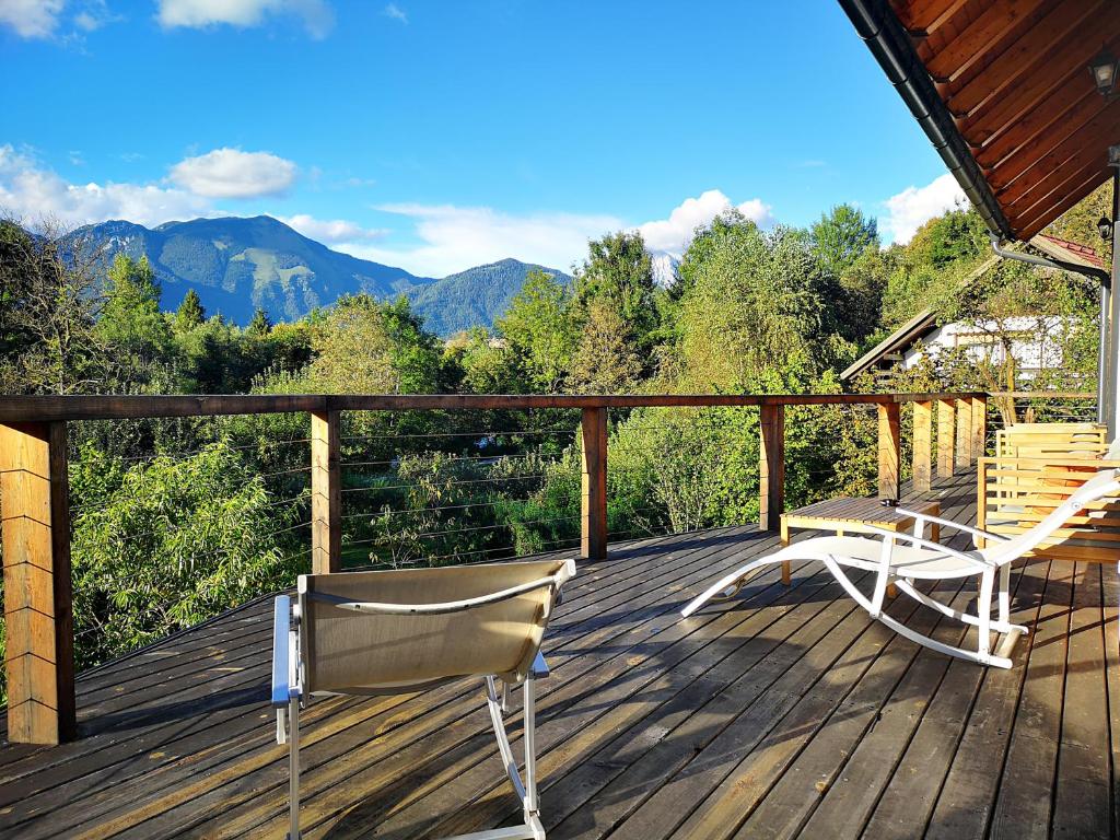 a deck with two chairs and mountains in the background at PR`FIK Apartments in Kranj