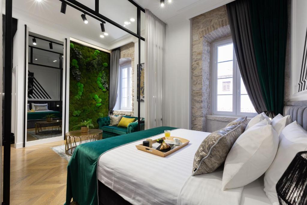 a bedroom with a bed with a tray of food on it at DeZign Superior Apartments & Rooms in Zadar