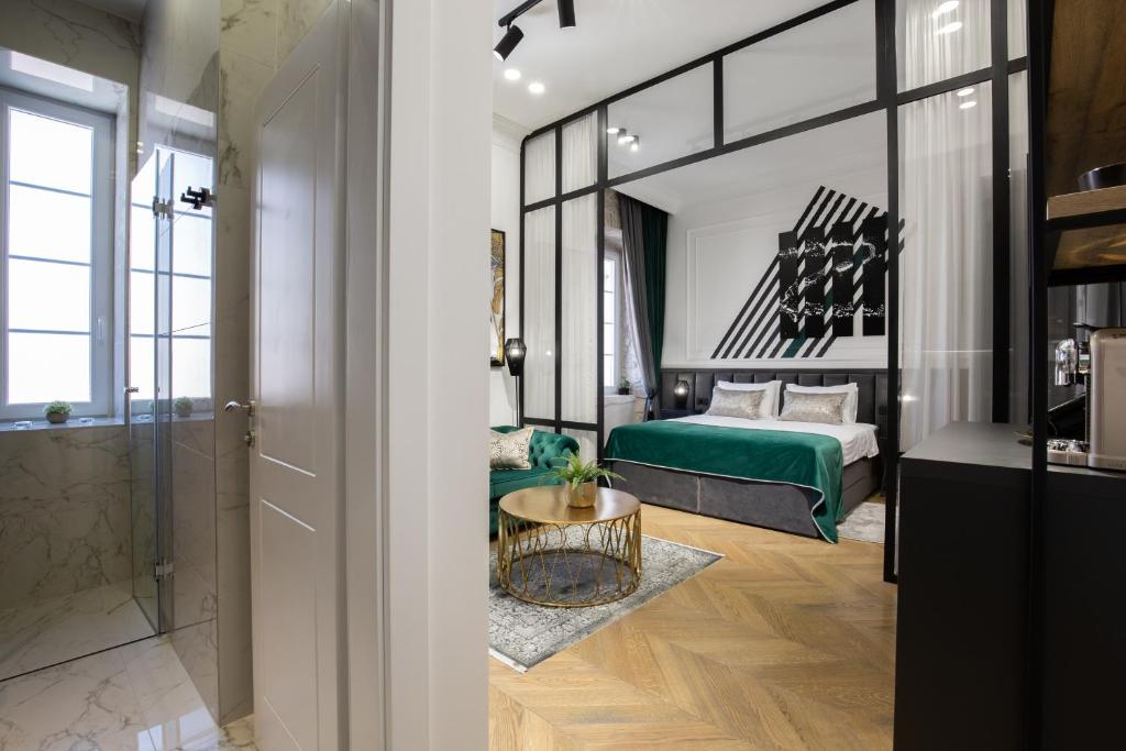 a bedroom with a green bed and a bathroom at DeZign Superior Apartments & Rooms in Zadar