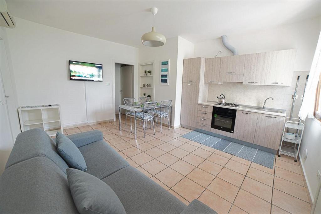 a living room with a couch and a kitchen at ALLORO APPARTAMENTO 1 - Piano Terra con terrazza. in Sirmione