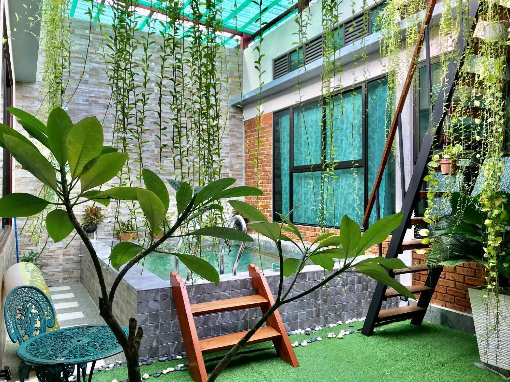 a balcony with two chairs and a plant at Adagaya Villa Langkawi - Private Pool Villa in Pantai Cenang