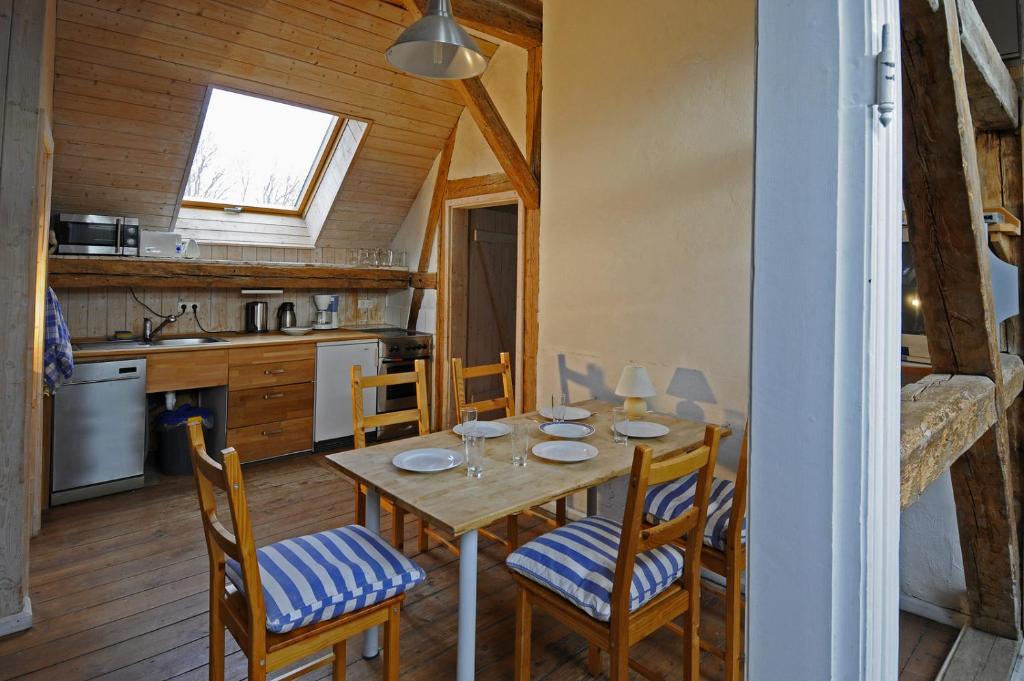 une salle à manger avec une table et des chaises dans une cuisine dans l'établissement Gutshaus Thorstorf FeWo Wolenberger Wiek, à Warnow