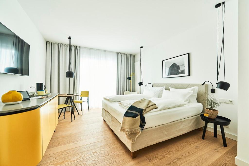 une chambre d'hôtel avec un lit et une cuisine dans l'établissement New Wave, à Norderney