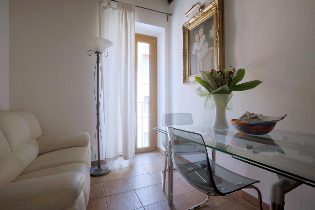 een woonkamer met een glazen tafel en een bank bij Borgo Pio 91 in Rome