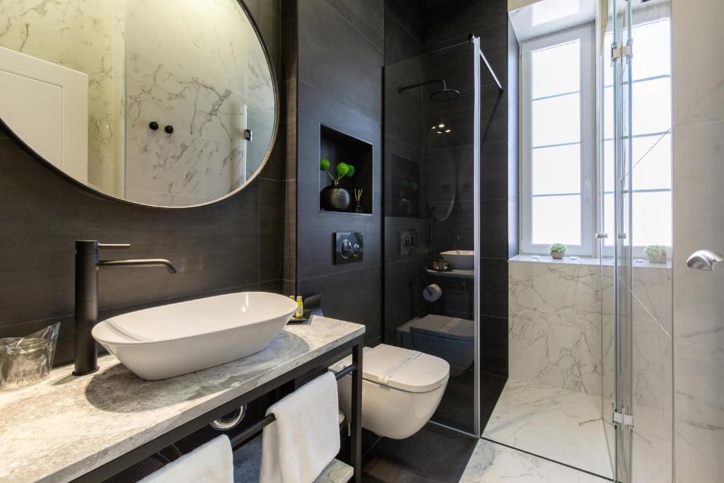 a bathroom with a sink and a toilet and a shower at DeZign Superior Apartments & Rooms in Zadar