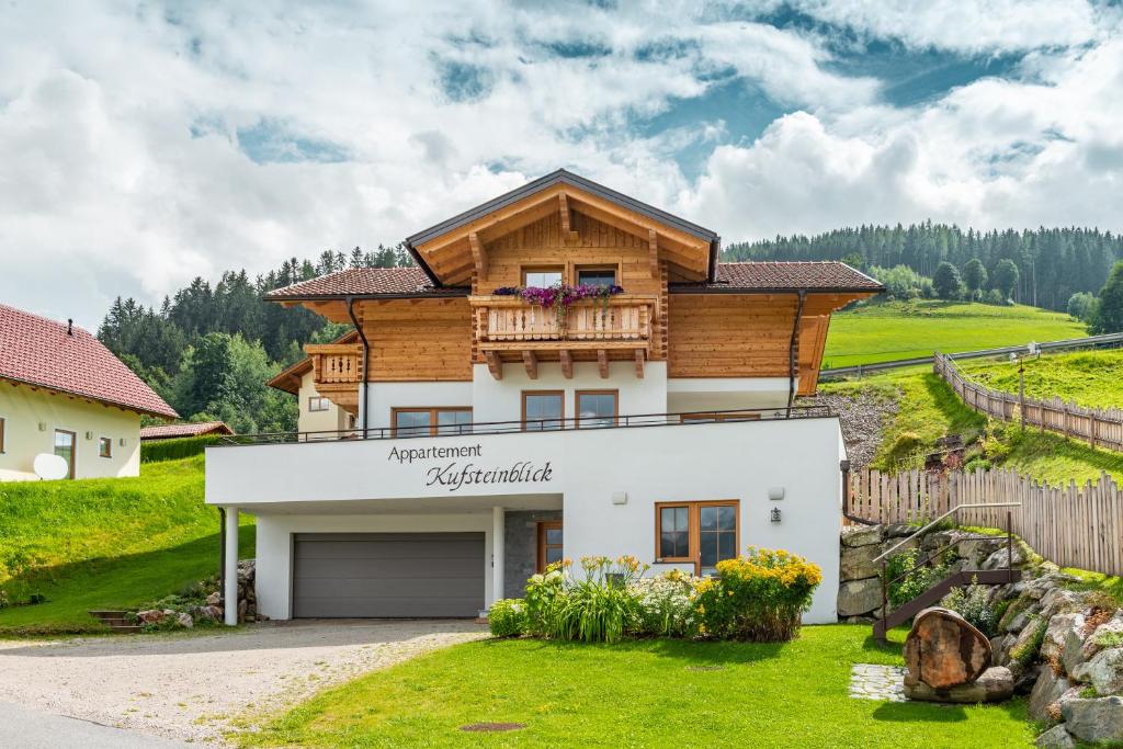 une maison sur une colline avec une clôture dans l'établissement Appartement Kufsteinblick, à Haus im Ennstal