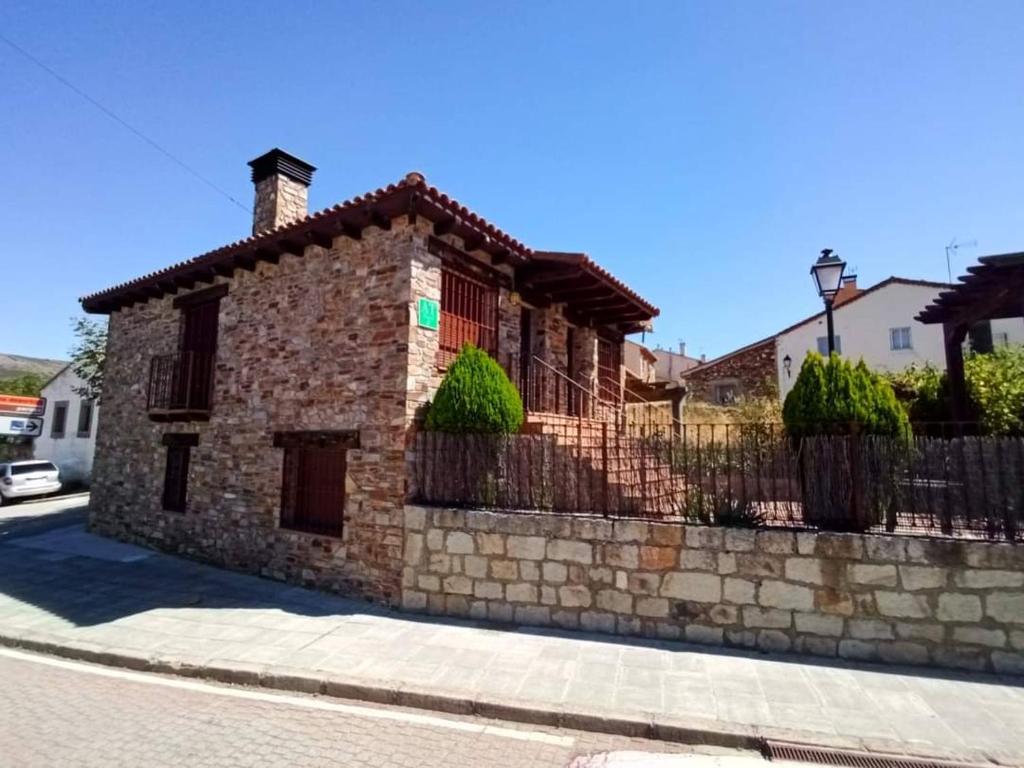 a stone house on the side of a street at Alojamiento rural "LA JARA" in Robledillo de la Jara