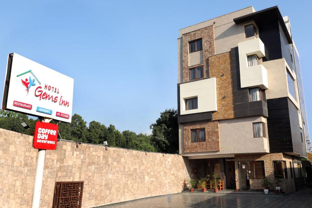 un edificio con una señal delante de él en Hotel Gems Inn, en Dehradun