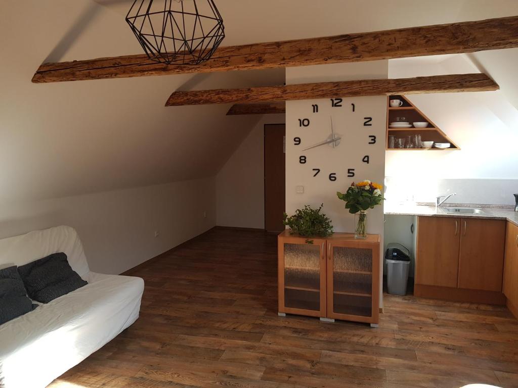 a living room with a large clock on the wall at Apartmany 123 in Broumov