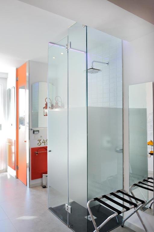 a glass shower in a bathroom with a chair at Hotel Boutique Sabbia Valencia in Valencia