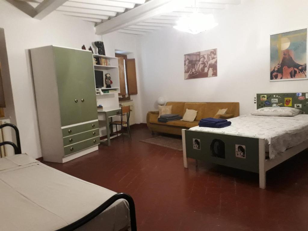 Pokój z 2 łóżkami i salonem z kanapą w obiekcie CASA FEDORA -Appartamento uso turistico centro storico di Arezzo w Arezzo