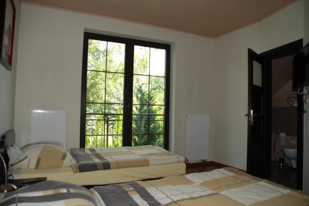 a room with two beds and a large window at VillaRenoma in Nadarzyn