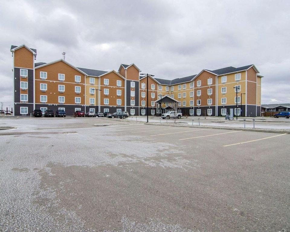 un parking en face d'un grand bâtiment dans l'établissement Quality Inn & Suites, à Estevan