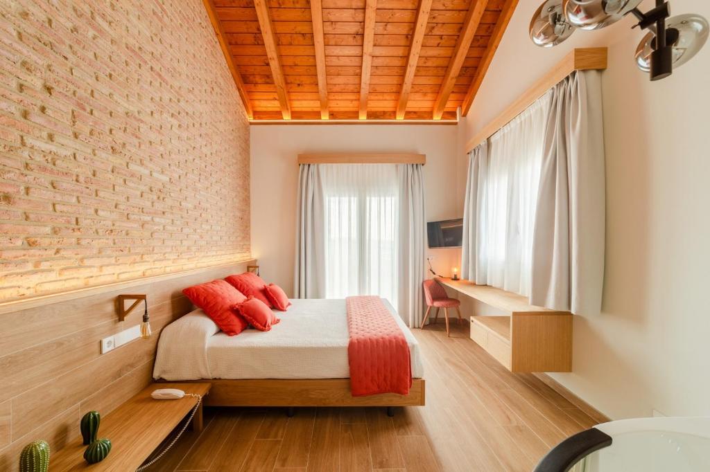 1 dormitorio con cama y pared de ladrillo en HOTEL RESTAURANTE CASA LUISA, en Estella