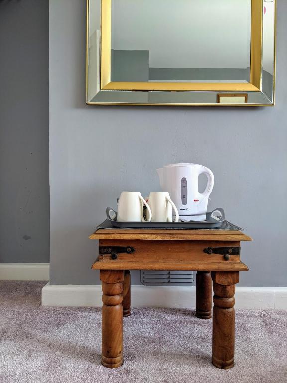 a table with two coffee cups and a mirror at Cottars in Winfrith Newburgh