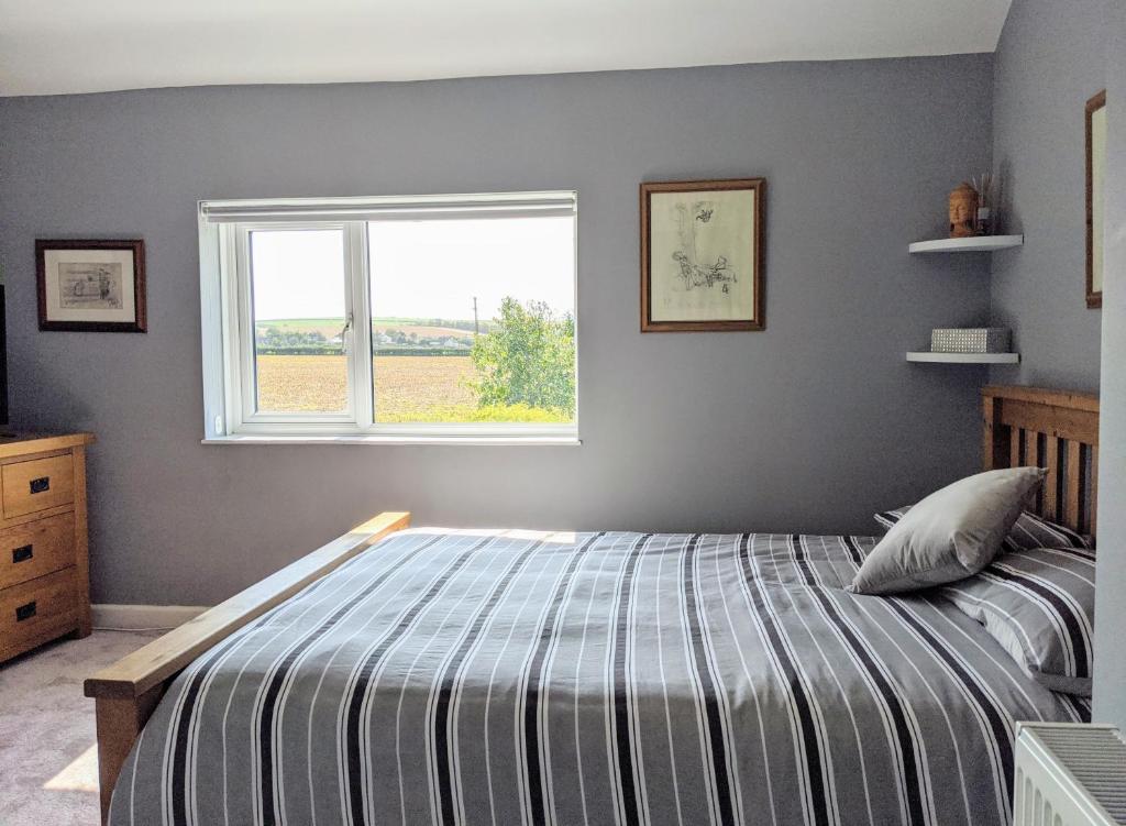 a bedroom with a bed and a window at Cottars in Winfrith Newburgh