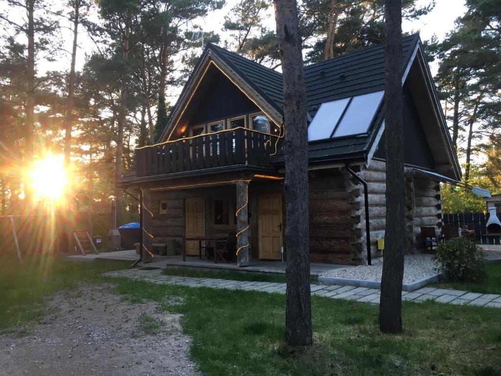 a cabin in the woods with the sun setting at Baltic Dream in Rozewie