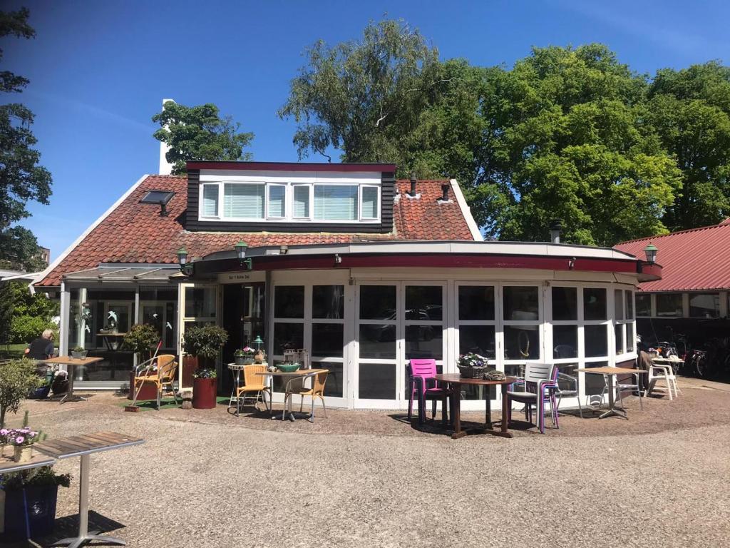 een gebouw met tafels en stoelen ervoor bij B&B Het Ruime Sop in Wassenaar