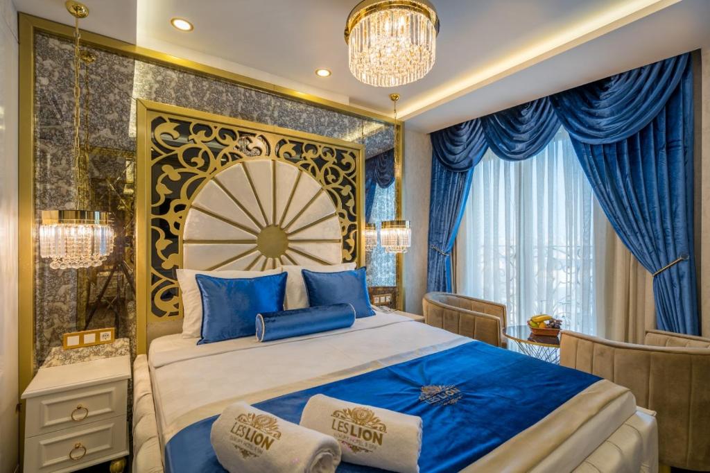 a bedroom with a large bed with blue pillows at Leslion Luxury Hotel in Antalya