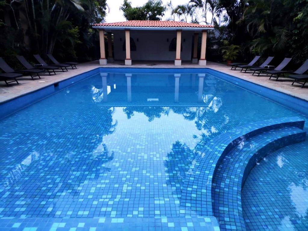 einen Pool mit blauem Fliesenboden und einem Pavillon in der Unterkunft Hotel Spa Posada Tlaltenango in Cuernavaca