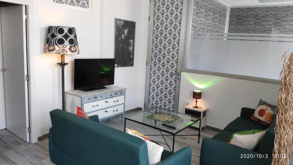 ein Wohnzimmer mit 2 Stühlen und einem TV in der Unterkunft Apartamento La Luna in Lumpiaque
