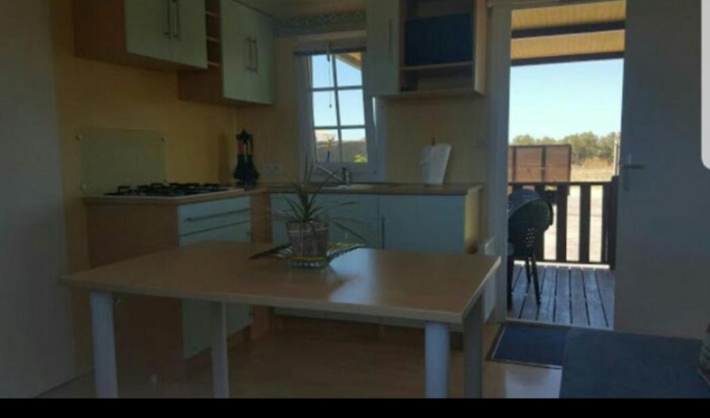 a kitchen with a table and a view of a balcony at Casa Prefabricada in El Palmar