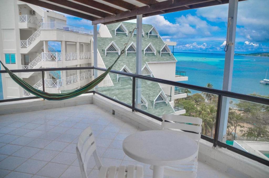 uma varanda com mesa e cadeiras e vista para o oceano em Apartamentos con espectacular vista al mar em San Andrés
