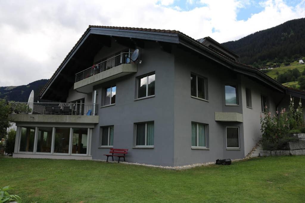 a house with a red bench in front of it at Ferienwohnung für 5 Personen in Cumpadials, inmitten der Surselva in Sumvitg