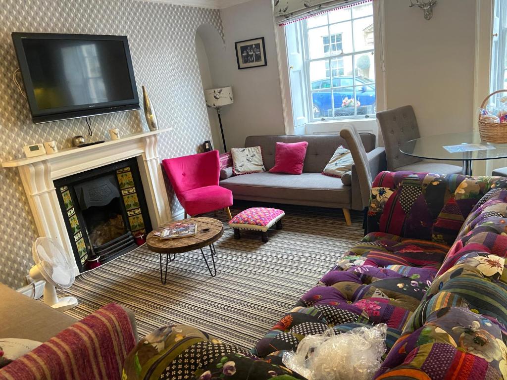 a living room with a couch and a fire place at Rivers Street 2 bed ground floor Georgian garden Apartment in Bath