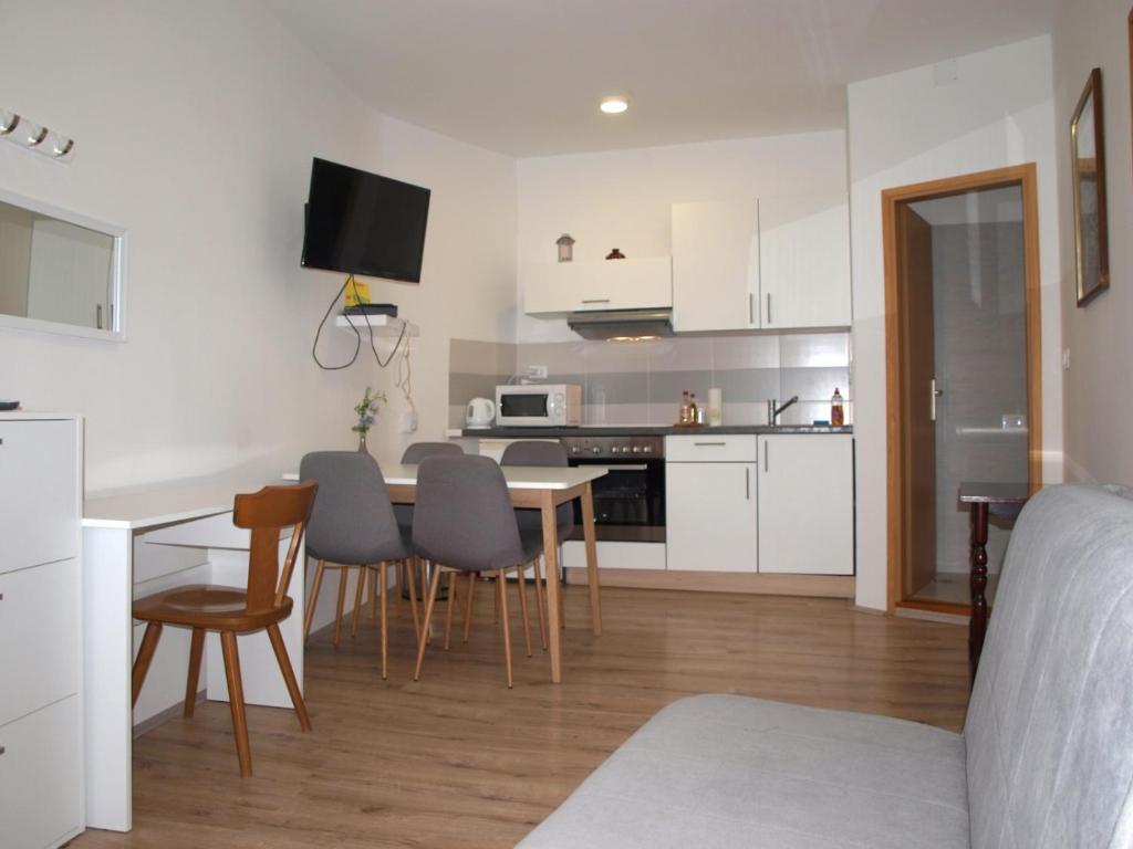 kuchnia i salon ze stołem i krzesłami w obiekcie Apartment MONTE w Rovinj