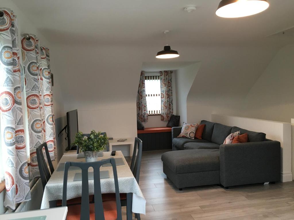 uma sala de estar com um sofá e uma mesa em Binnian View Apartment em Kilkeel