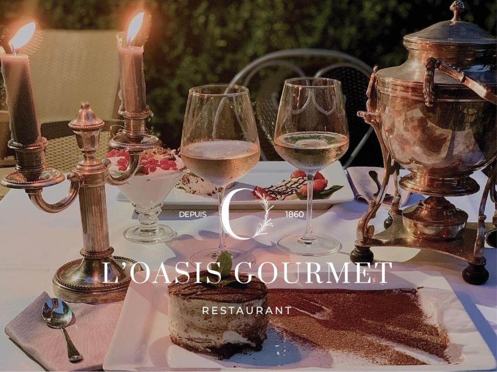 a table with three glasses of wine on it at Hôtel restaurant Oasis in Nice