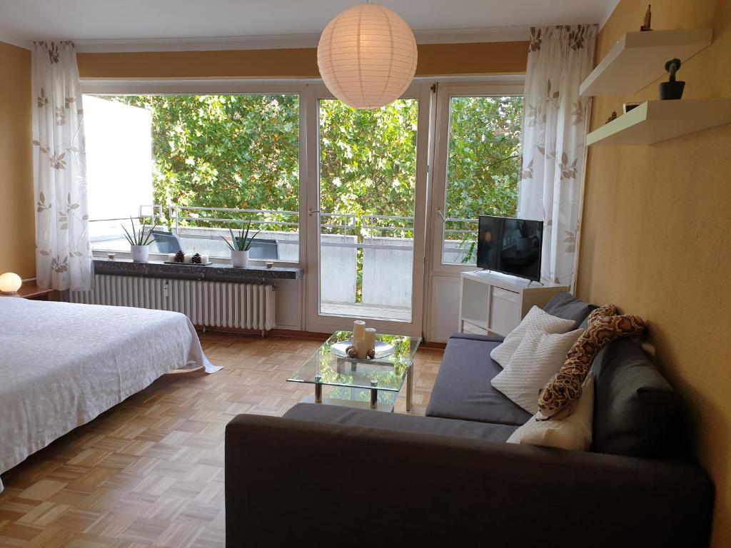 - un salon avec un canapé, un lit et des fenêtres dans l'établissement Renoviertes Wohlfühlapartment, à Hagen
