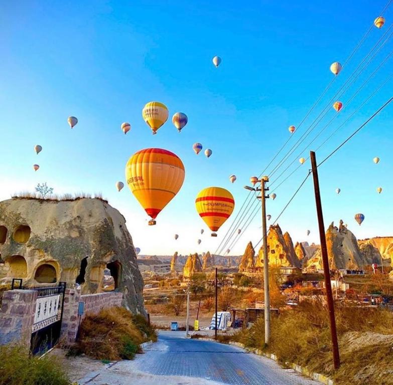 a bunch of hot air balloons flying in the sky at Cappadocian Special House in Goreme