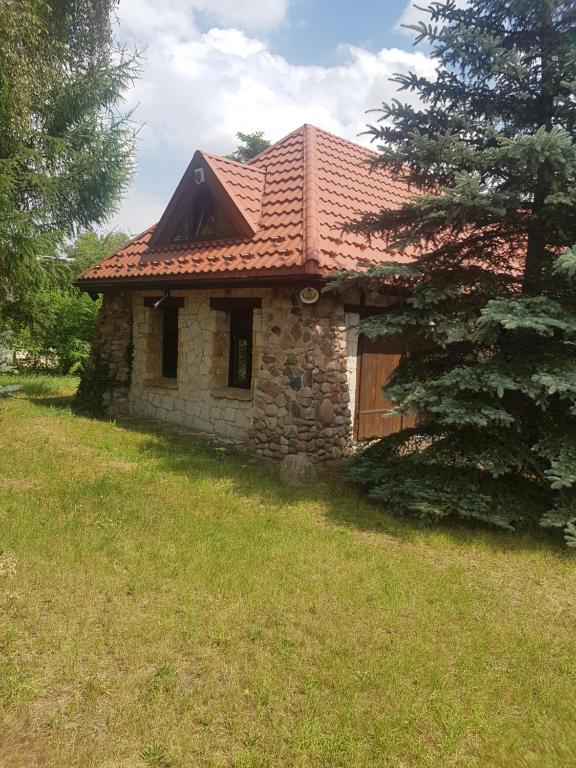 a small stone house with a red roof at Babie lato . in Brudnów