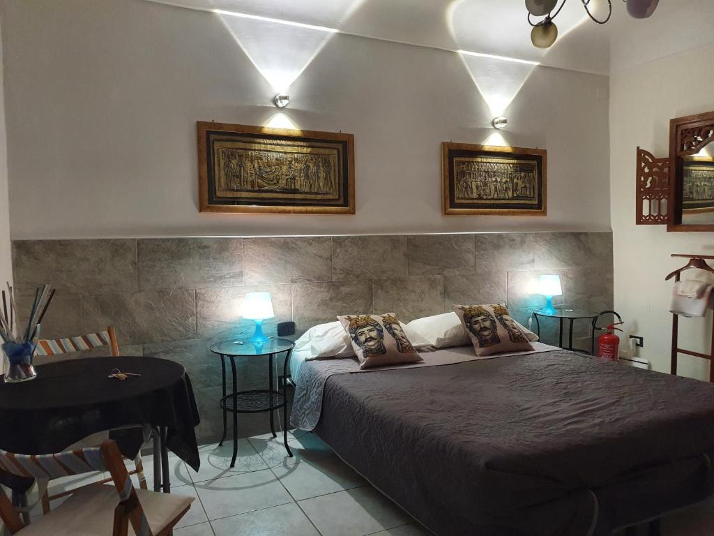 1 dormitorio con 1 cama, mesa y sillas en Le Pergole 21, en San Cataldo