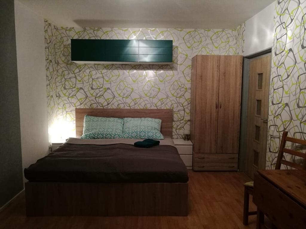 a bedroom with a bed and a television on the wall at Apartment Oltec in Bohunice