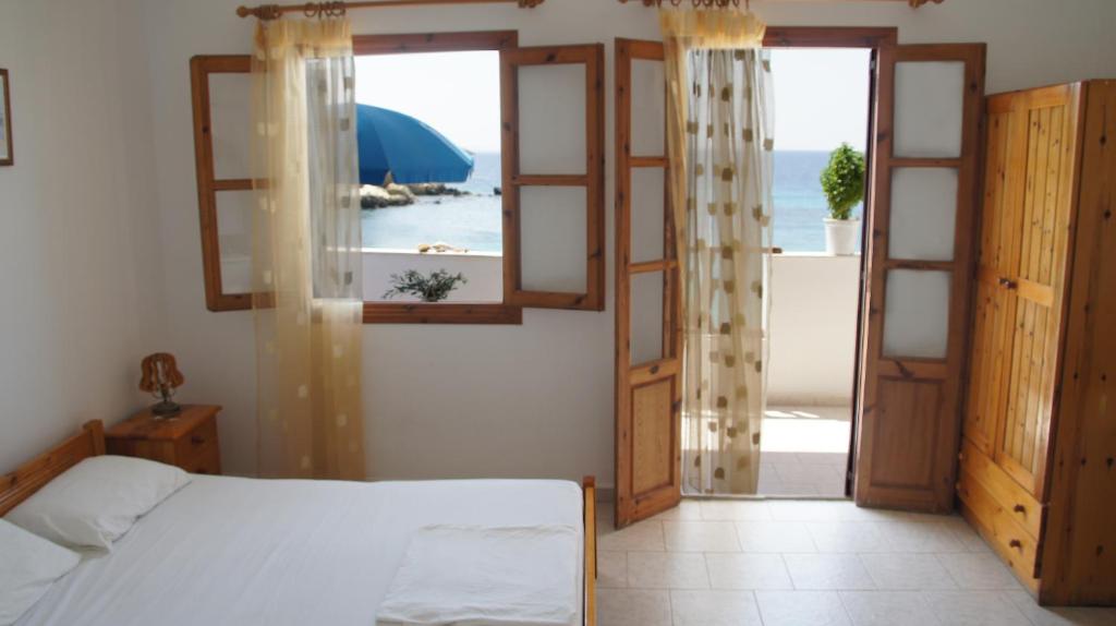 a bedroom with a bed and a view of the ocean at Nikos Studios in Lefkos Karpathou