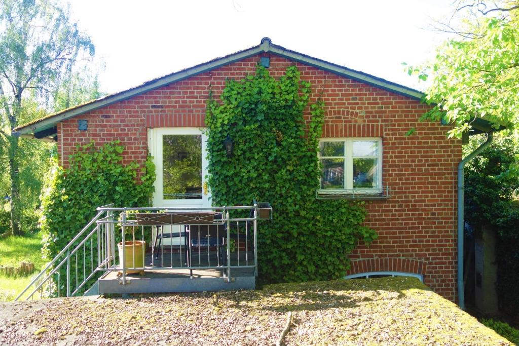 a red brick house with a balcony in front of it at FeWo Tilda in Garlstorf