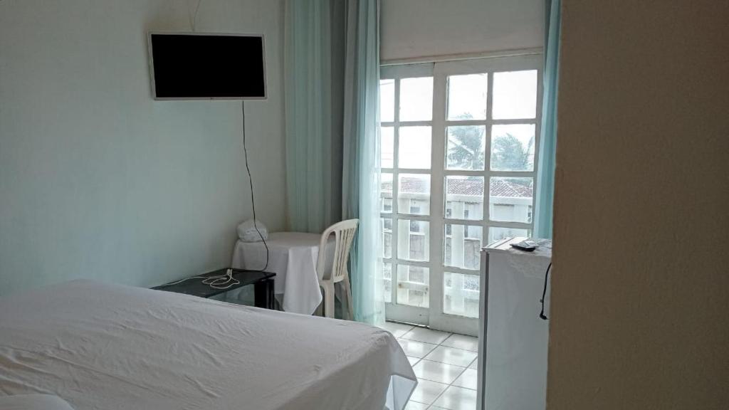 um quarto com uma cama e vista para uma janela em Pousada Solar di Poletti em Nísia Floresta