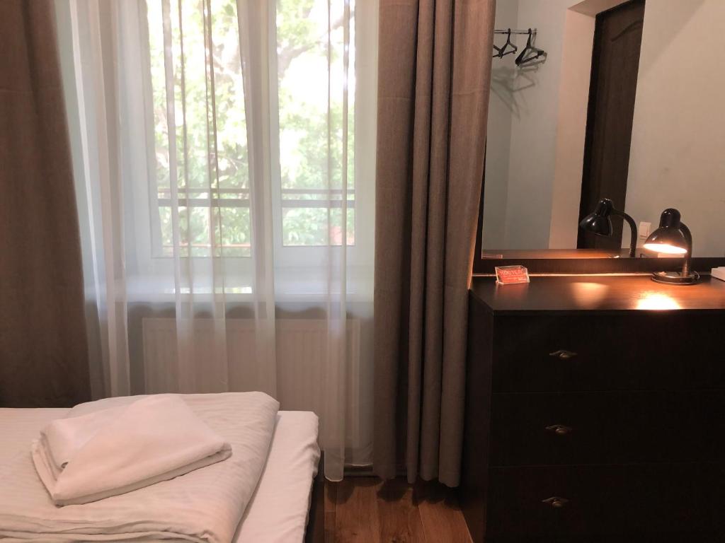 um quarto com uma cama, uma cómoda e um espelho em Fox Hostel em Nikolayev