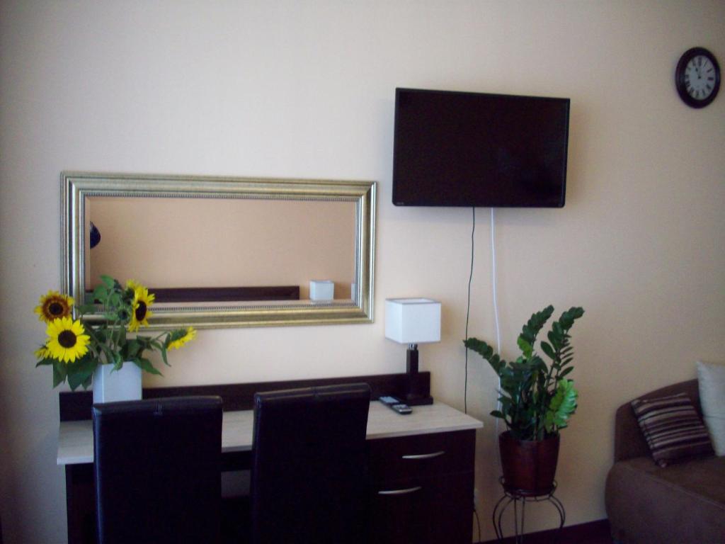 Habitación con escritorio, espejo y sofá. en Apartamenty Arka Medical Spa **** en Kołobrzeg