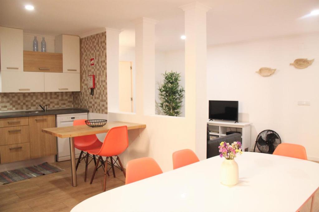 une cuisine avec des chaises orange et un comptoir blanc dans l'établissement RomanticHome at Alfama's Heart, à Lisbonne