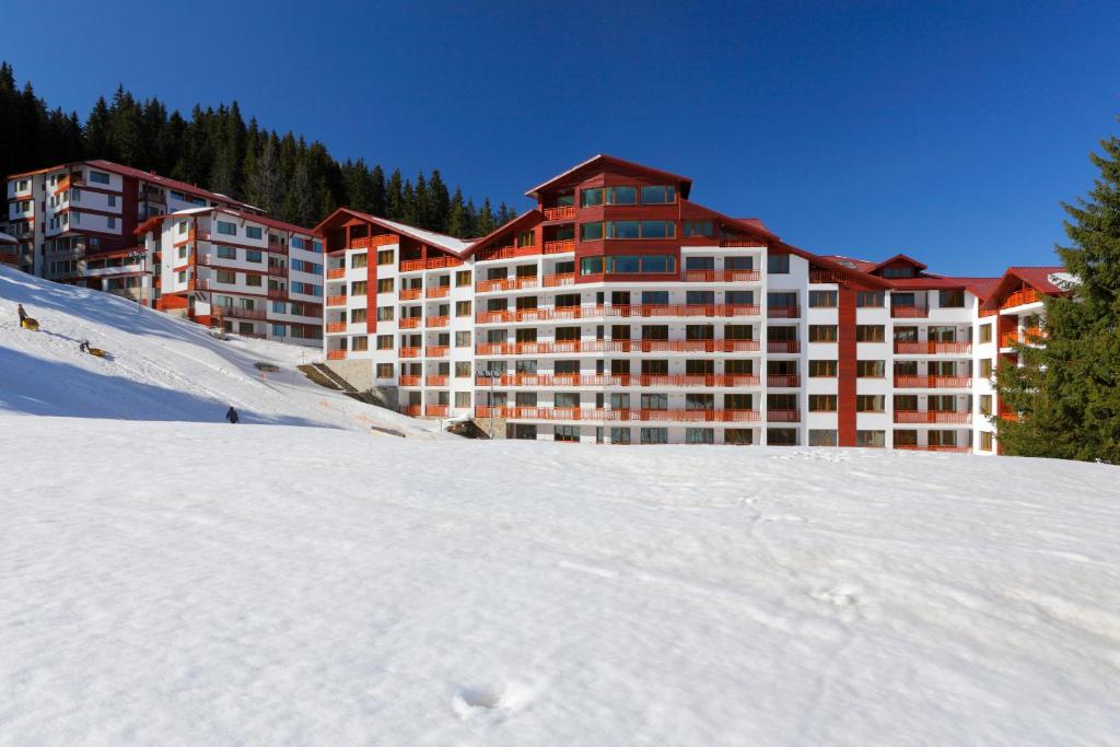 a large building in the snow in front at Forest Nook Aparthotel in Pamporovo