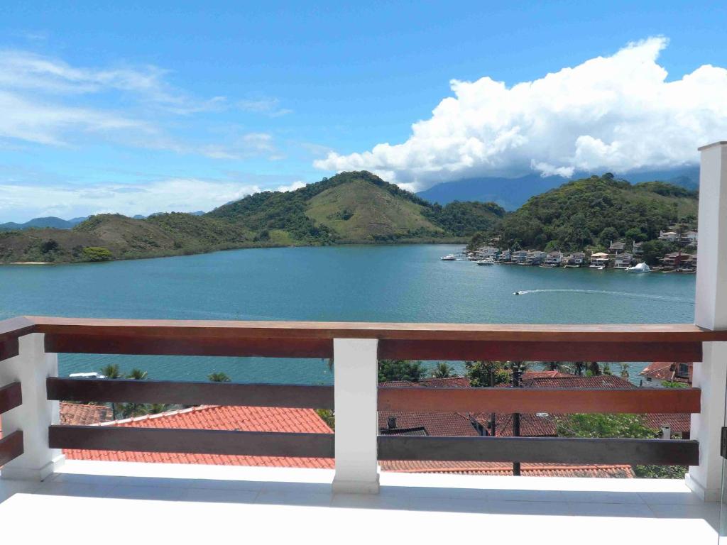a bench on a balcony overlooking a lake at Casa em Angra dos Reis no Paraíso do Condomínio do Engenho in Angra dos Reis