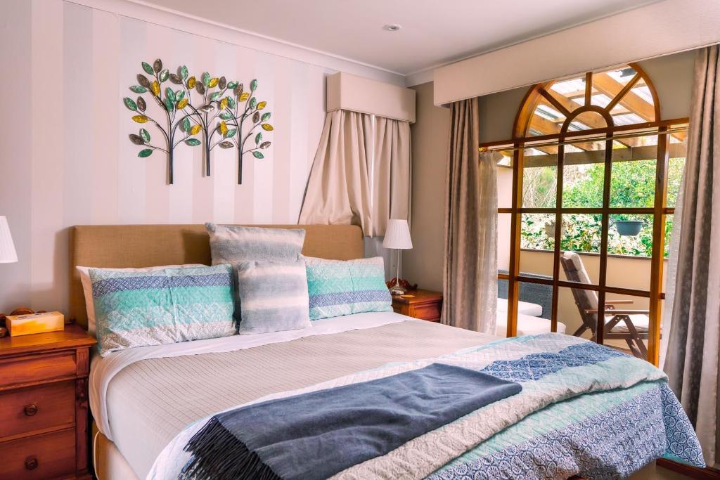 a bedroom with a large bed and a large window at Amble at Hahndorf in Hahndorf