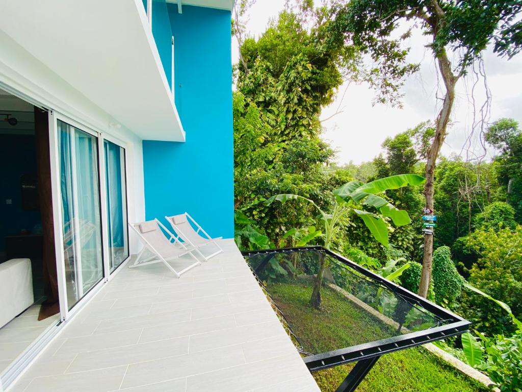 a balcony with a view of a house at L'ylang ylang in Petit-Bourg