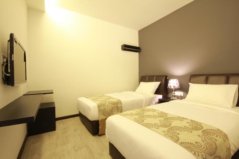 Postel nebo postele na pokoji v ubytování Sandy Hotel Malacca